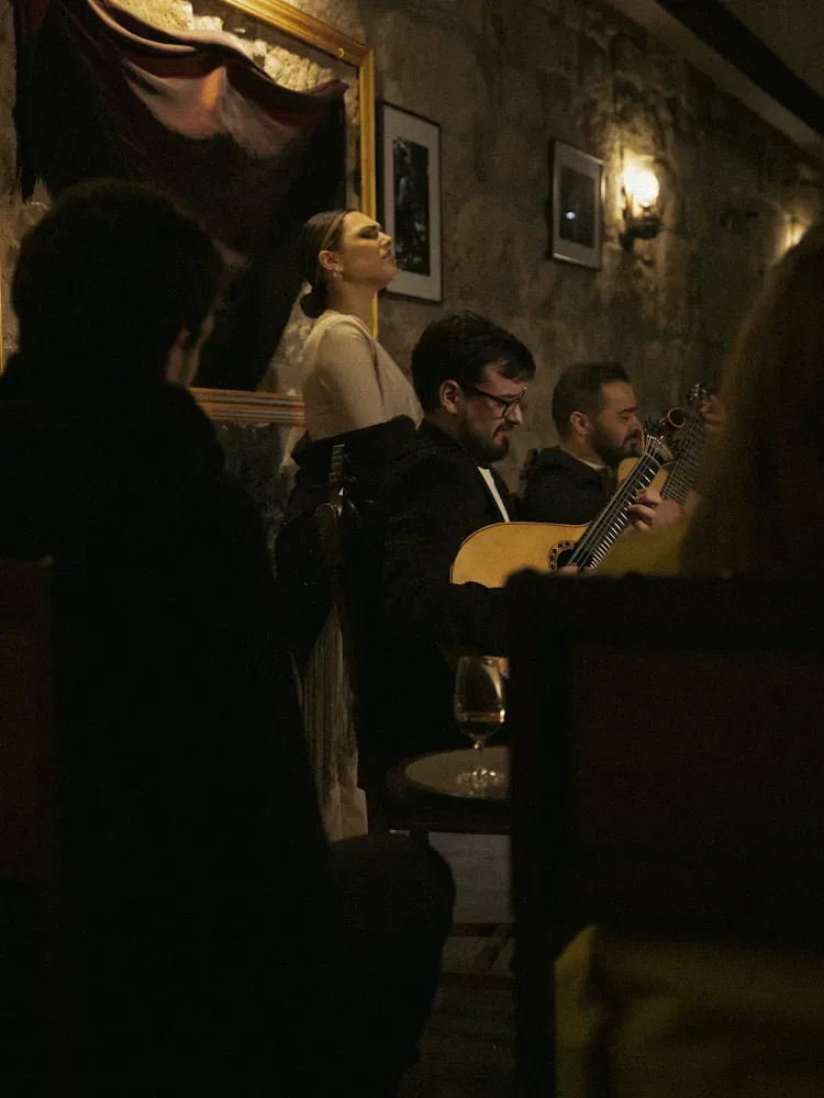 Fadista e guitarristas numa casa de fado